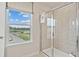Bathroom with tile shower, view to the outside, and framed roller shade at 201 Lytham Se Dr, Mableton, GA 30126