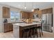 Kitchen island with bar stool seating, pendant lights, stainless appliances, and gray cabinets at 213 Lytham Se Dr, Mableton, GA 30126