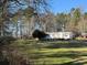 Well-maintained single-story home with a large front yard and mature trees on a sunny day at 291 Folsom Glade Rd, Rydal, GA 30171