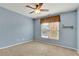 This bedroom has carpet flooring, a ceiling fan and a window that provides natural light at 345 Oakwind Pt, Acworth, GA 30101