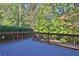 Outdoor deck with wooden railing and a view of the surrounding trees at 345 Oakwind Pt, Acworth, GA 30101