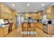Bright eat-in kitchen with hardwood floors, stainless appliances, wood cabinets, island with seating, and desk area at 345 Oakwind Pt, Acworth, GA 30101