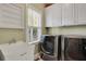 This laundry room features a utility sink, modern washer and dryer, and custom cabinets at 345 Oakwind Pt, Acworth, GA 30101