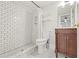 Bathroom featuring a white tile shower, matching hexagonal tile floor, and wooden vanity at 616 N Highland Ne Ave # 13B, Atlanta, GA 30306