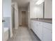 Modern bathroom with gray tile floor, a walk-in shower, and bright white cabinets at 2256 Cadenza Cir, Dacula, GA 30019