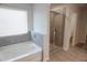 Bright bathroom with tub, shower, and gray tiled walls at 2256 Cadenza Cir, Dacula, GA 30019