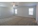 Spacious bedroom featuring neutral carpet, two windows, and a ceiling fan at 2256 Cadenza Cir, Dacula, GA 30019