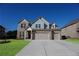 Inviting two-story brick home featuring a three-car garage and a well-manicured lawn at 2256 Cadenza Cir, Dacula, GA 30019