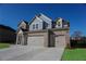 Two-story brick home showcasing a spacious three-car garage and manicured landscaping at 2256 Cadenza Cir, Dacula, GA 30019