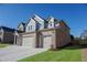 Two-story brick home with a spacious three-car garage and lush green lawn at 2256 Cadenza Cir, Dacula, GA 30019