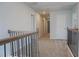 Upstairs hallway with iron railing, neutral walls and carpet at 2256 Cadenza Cir, Dacula, GA 30019