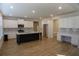 Open-concept kitchen boasting a large island, white cabinets, stainless steel appliances and hardwood floors at 2256 Cadenza Cir, Dacula, GA 30019