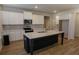Spacious kitchen with a dark island, stainless appliances, white cabinets, and hard wood floors at 2256 Cadenza Cir, Dacula, GA 30019