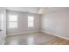 Bright bedroom features wood-look flooring, two windows, and modern ceiling fan at 669 Hunting Creek Se Ln, Conyers, GA 30013