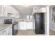 Well-lit kitchen with stainless steel appliances, white cabinetry, and granite countertops at 669 Hunting Creek Se Ln, Conyers, GA 30013