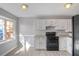 Bright eat-in kitchen featuring a large window, white cabinets and black appliances at 669 Hunting Creek Se Ln, Conyers, GA 30013