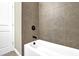 Clean white bathtub with bronze fixtures and gray tiled walls creating a relaxing bathroom at 108 Blakemore Se Dr, Smyrna, GA 30080