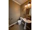 Traditional half bath features ceramic tile, a pedestal sink, and decorative lighting at 136 Hunters Ct, Dallas, GA 30157