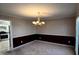 Cozy dining area featuring wainscoting, wallpaper, a chandelier, and a large window at 136 Hunters Ct, Dallas, GA 30157