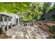 Stone patio featuring an outdoor seating area, landscaping, and a lush tree canopy at 17 Blackland Rd, Atlanta, GA 30342