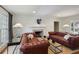Cozy living room with tufted leather sofas, a fireplace, and ample natural light exudes comfort at 17 Blackland Rd, Atlanta, GA 30342