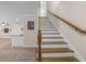 Carpeted staircase with wooden banister and white risers, leading to the upper level of the home at 209 Windsor Green Ct, Canton, GA 30115