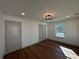 Bright bedroom featuring hardwood floors, a modern light fixture, and neutral paint at 3629 Stewart Rd, Atlanta, GA 30340