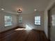 Light-filled bedroom with hardwood floors, a modern light fixture, and three windows at 3629 Stewart Rd, Atlanta, GA 30340