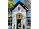 A beautiful home featuring a white facade, arched doorway, and a modern black door, complemented by stylish black hardware and lighting at 3629 Stewart Rd, Atlanta, GA 30340