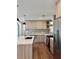 Modern kitchen featuring sleek appliances, wood-grain cabinets, a tile backsplash, hardwood floors, and an island with a sink at 3629 Stewart Rd, Atlanta, GA 30340