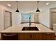 A modern kitchen features an island with a sink, wood-grain cabinets, and access to a living room with large windows at 3629 Stewart Rd, Atlanta, GA 30340