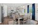 Bright dining area with a wooden table set for six, complemented by modern pendant lights and a view to the kitchen at 525 Lanier Way, Temple, GA 30179