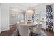 Cozy dining area with a round table, six chairs, and elegant decor, illuminated by a contemporary chandelier at 525 Lanier Way, Temple, GA 30179