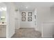 Hallway with wall art and an entrance to a bathroom, featuring neutral carpet at 525 Lanier Way, Temple, GA 30179