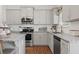 Well-lit kitchen with stainless steel appliances, granite countertops, and ample storage space in the gray cabinetry at 525 Lanier Way, Temple, GA 30179
