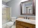 Neutral bathroom featuring a shower, toilet, sink with a light countertop, and wood cabinets at 6067 Dana Dr, Norcross, GA 30093