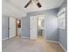 Bedroom featuring neutral walls, carpet, a window, a ceiling fan, and a view into the bathroom at 6067 Dana Dr, Norcross, GA 30093