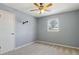 Bedroom featuring neutral walls, carpet, a window, a ceiling fan, and door at 6067 Dana Dr, Norcross, GA 30093