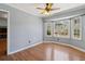 Bright living room with hardwood floors, a ceiling fan, and a bay window overlooking the backyard at 6067 Dana Dr, Norcross, GA 30093