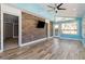 Bright living room features light wood floors, brick accent wall, and a ceiling fan at 6067 Dana Dr, Norcross, GA 30093