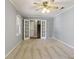 Carpeted living room boasts a ceiling fan, neutral walls, french doors, and a view of the staircase at 6067 Dana Dr, Norcross, GA 30093