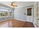 Light-filled room featuring hardwood floors, a ceiling fan, and a large window with backyard views at 6067 Dana Dr, Norcross, GA 30093