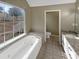 Bright bathroom with a soaking tub, a window, and tile flooring at 21 Fortson Dr, Hampton, GA 30228