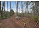 Secluded backyard area with a decorative stone patio and bench, nestled among mature trees at 3114 Superior Dr, Dacula, GA 30019