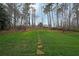 Large, lush backyard with a stone path leading to a wooded area, perfect for outdoor enjoyment at 3114 Superior Dr, Dacula, GA 30019