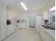 Bright kitchen features white cabinets, appliances, and a double basin sink near the window at 3114 Superior Dr, Dacula, GA 30019