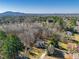 Aerial view of a home surrounded by lush trees, with mountains in the distance, showcasing its serene location at 504 Hanover Ct, Woodstock, GA 30188