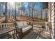Comfortable back porch with a white railing, wicker furniture, and a peaceful wooded backyard view at 504 Hanover Ct, Woodstock, GA 30188