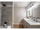 Modern bathroom features a tub-shower combo, grey tile, vanity with double sinks, and black hardware at 504 Hanover Ct, Woodstock, GA 30188