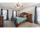 Comfortable bedroom features a ceiling fan, hardwood furniture, and natural light from the windows at 504 Hanover Ct, Woodstock, GA 30188